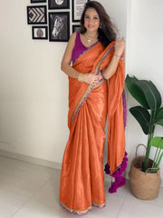 Modern Orange Satin-Finish Saree with Purple Sleeveless Blouse & Tassel Detail