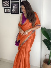 Modern Orange Satin-Finish Saree with Purple Sleeveless Blouse & Tassel Detail